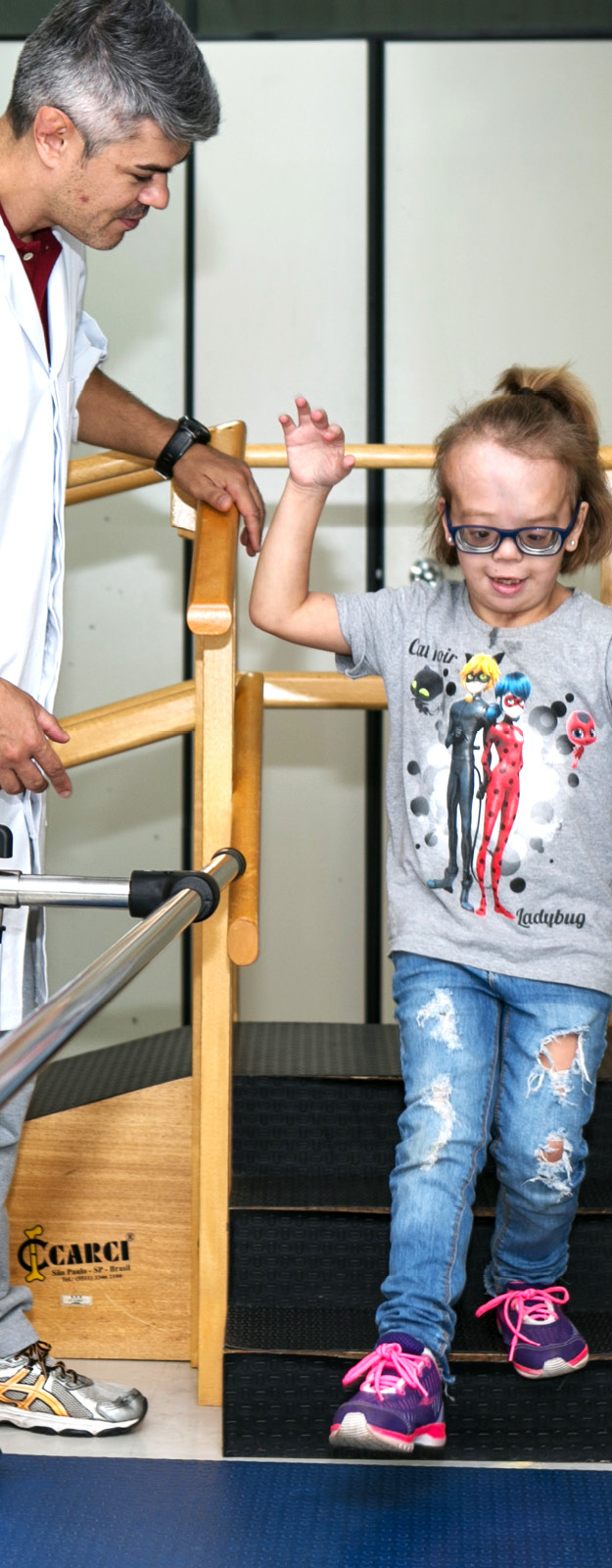 Fisioterapeuta atende menina pequena em rampa de caminhada