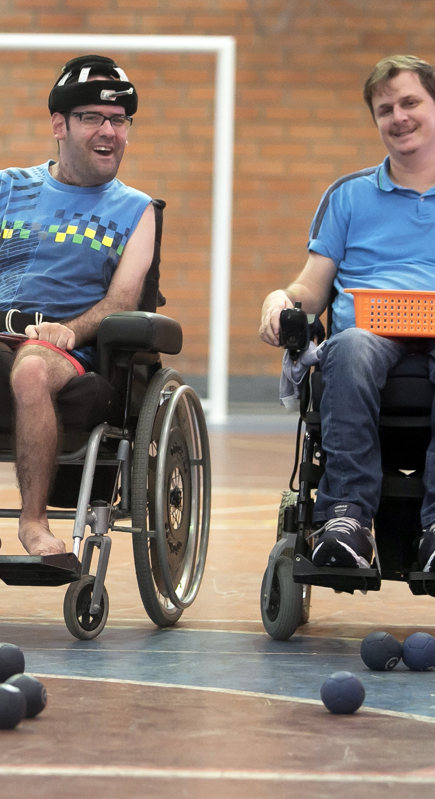 Dois cadeirantes posam para foto em ginásio de esportes