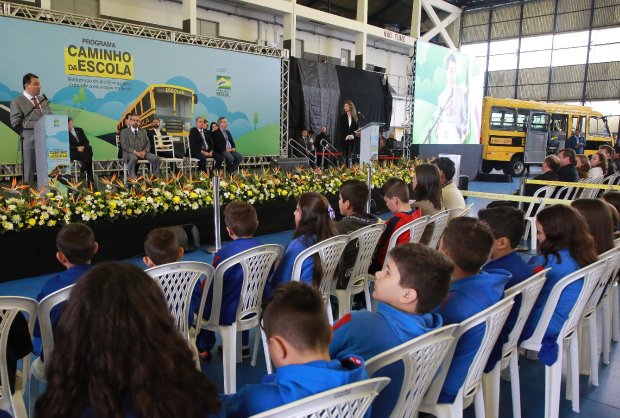 Governador Carlos Moisés discursa palco diante de plateia com estudantes. No canto direito do palco a interprete de LIBRAS. 