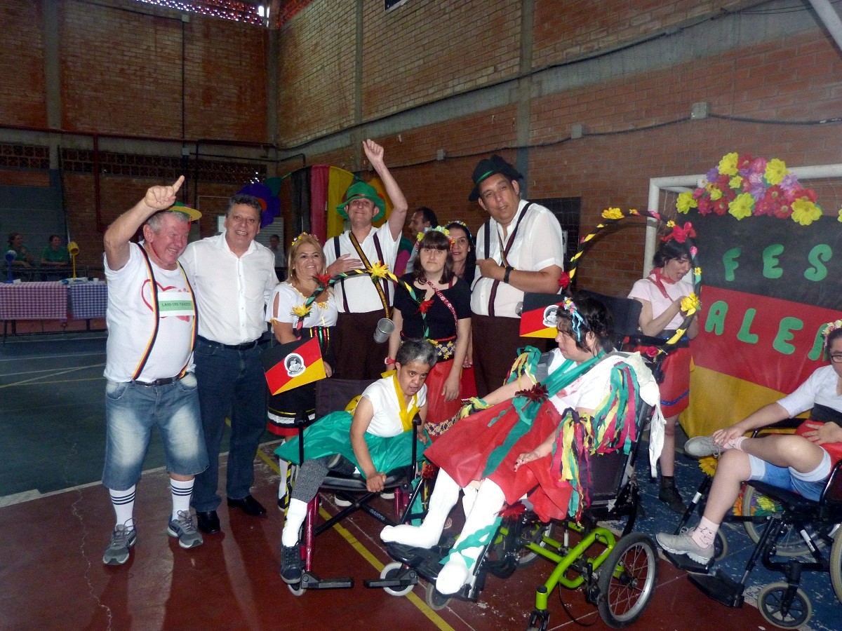 Presidente Rubens Feijó posa para foto no Ginásio cercado por educandos com trajes típicos alemães