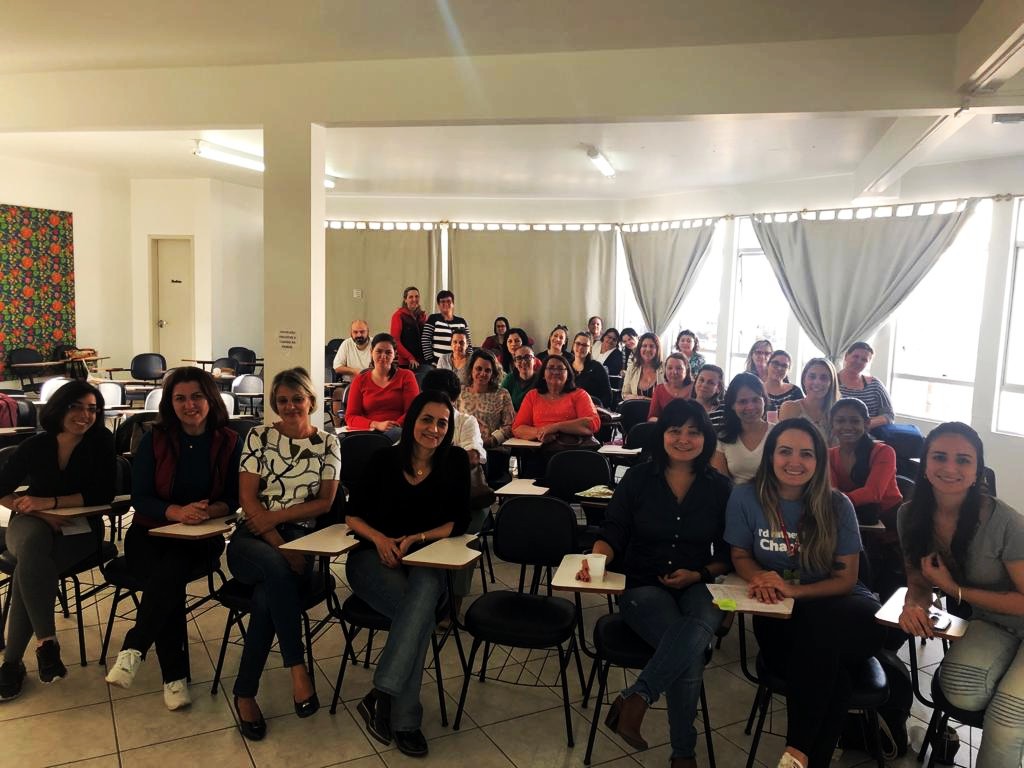 Grupo de 60 professores posam para foto em sala de aula com docentes da FCEE