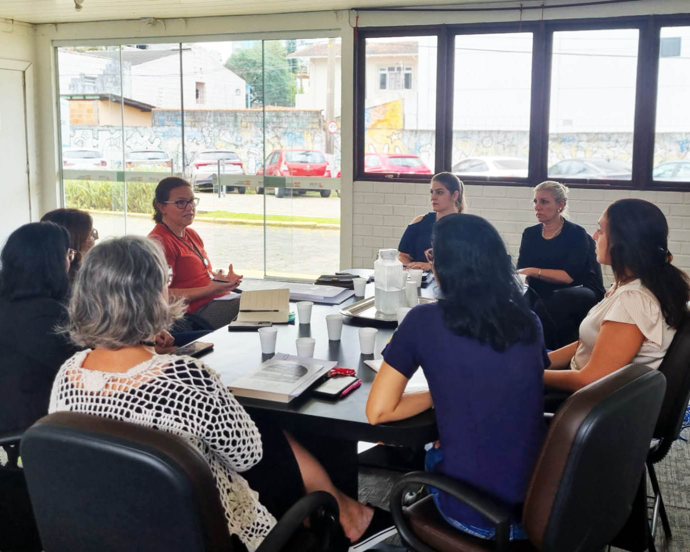 sala de reuniões, 8 mulheres sentadas conversando