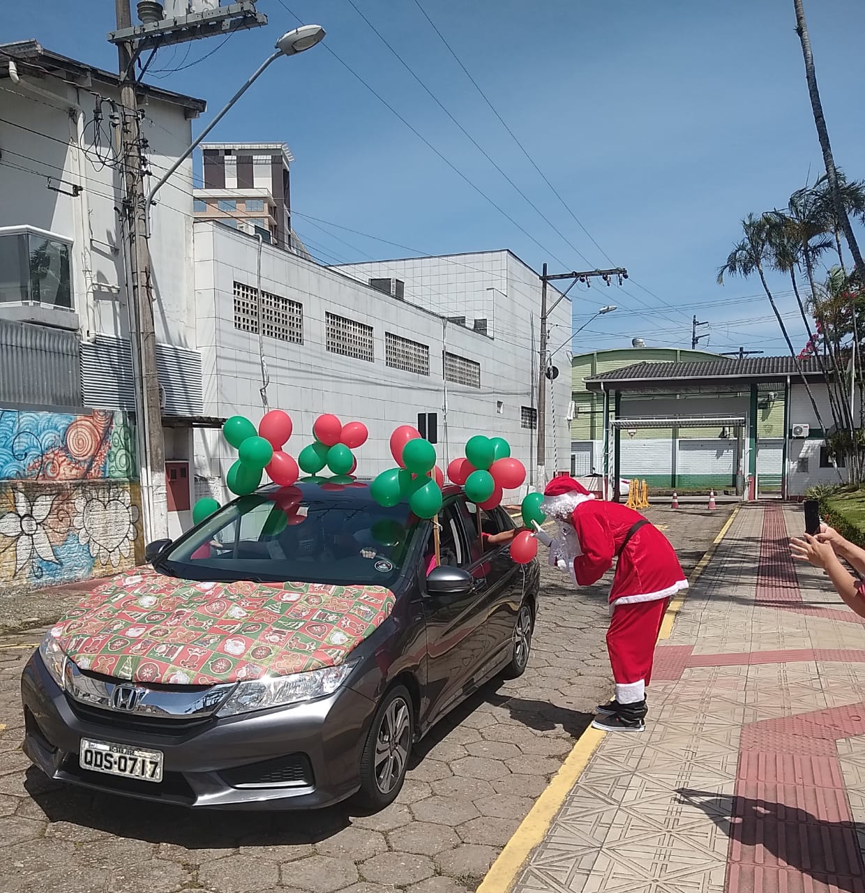 Veículo enfeitado com balões verde e vermelho e com pano temático de Natal entra no campus da Fundação
